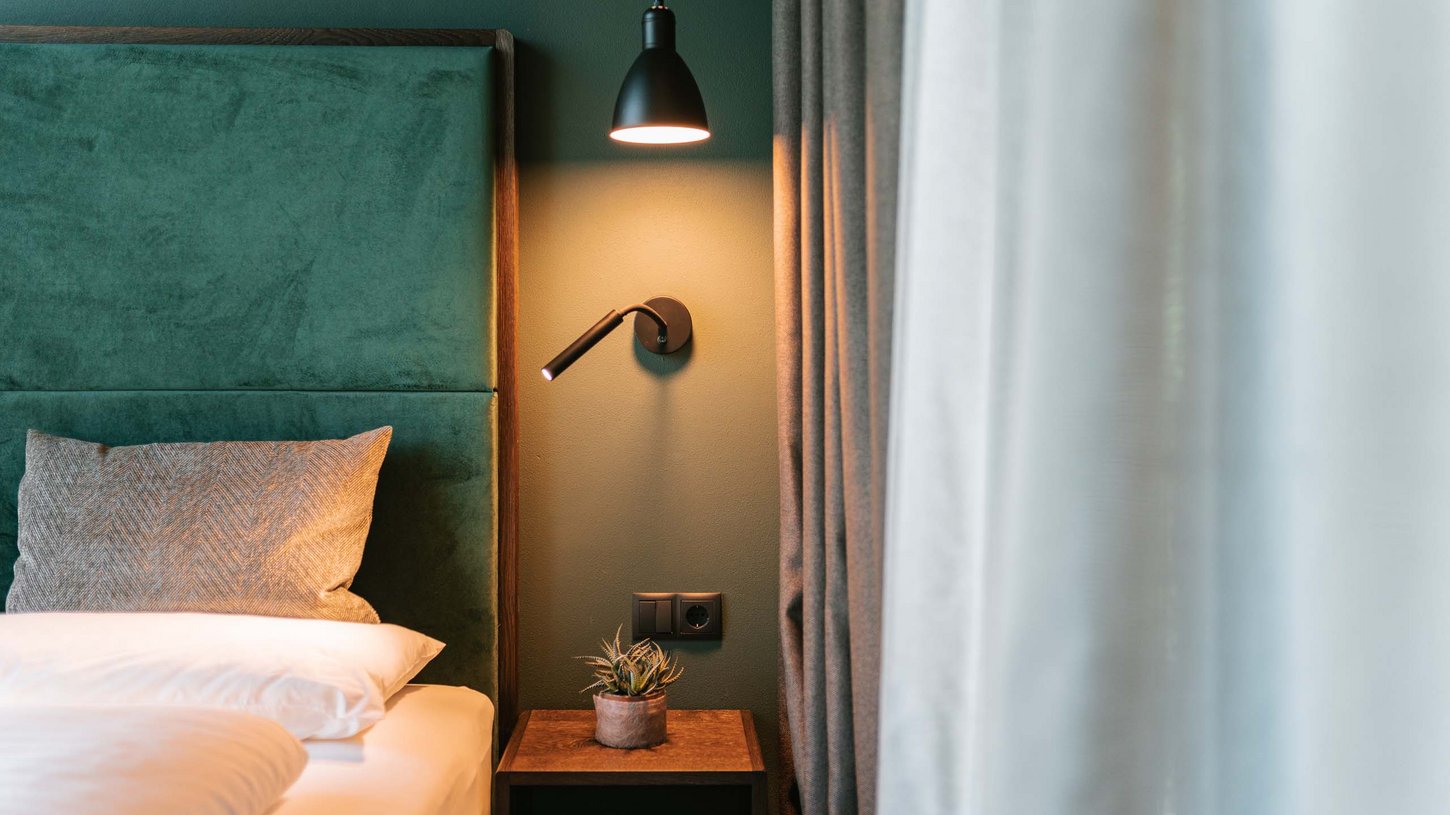 Gemütliches Schlafzimmer im Chalet mit moderner Beleuchtung Chalet-Schlafzimmer mit Bett und Lampe